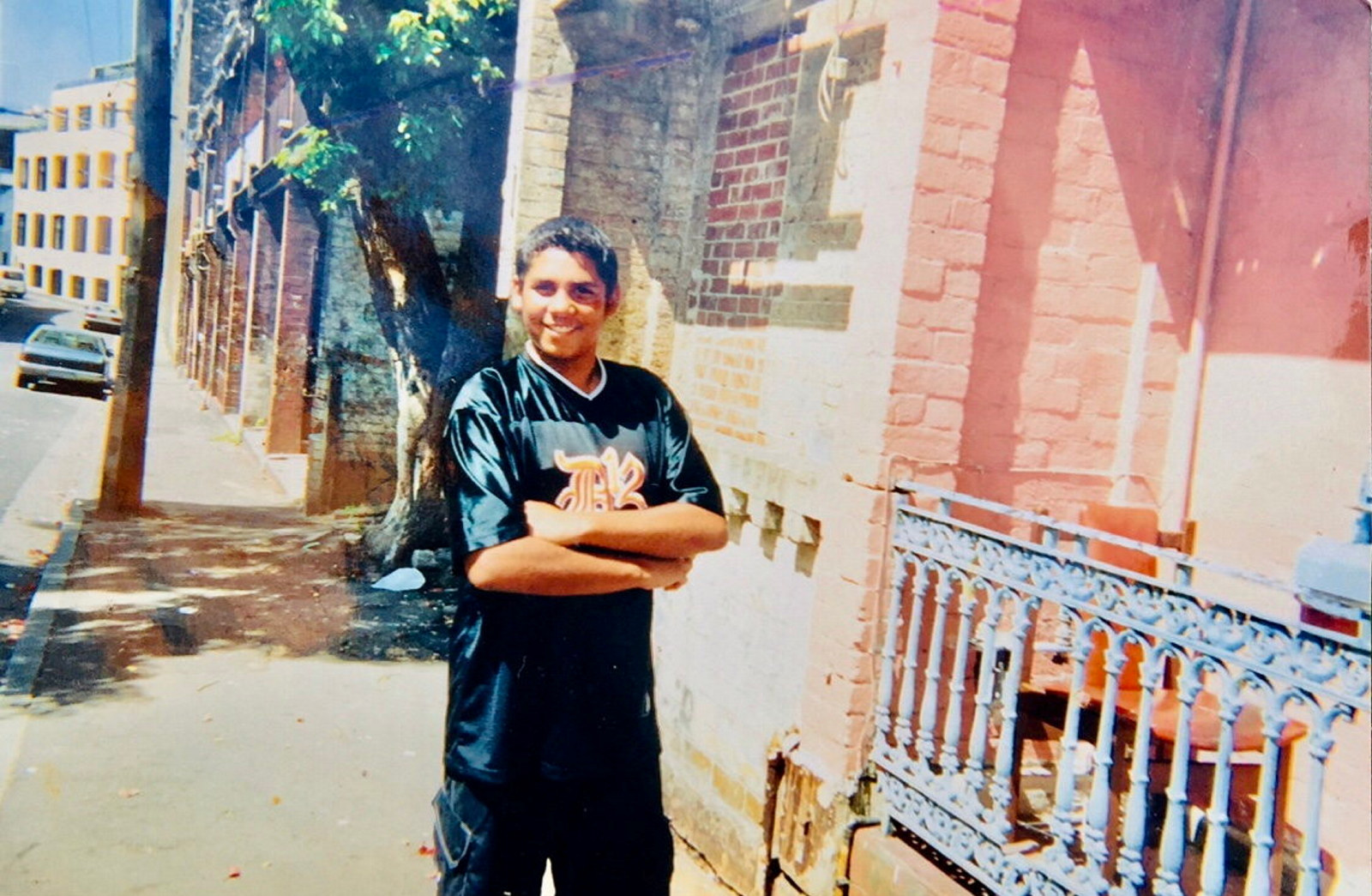 Dennis Golding outside his grandmother's house on Eveleigh Street, Redfern, 2003. Reproduction of photograph by Felicity Weatherall.