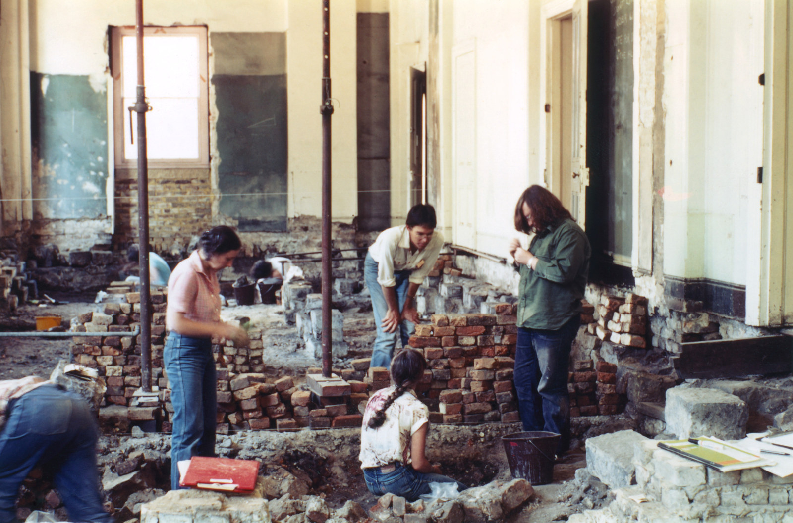 Archaeological excavation of the north-east ground floor room of Hyde Park Barracks, 1981. Robert Varman looking at Elizabeth Pinder, with three volunteers