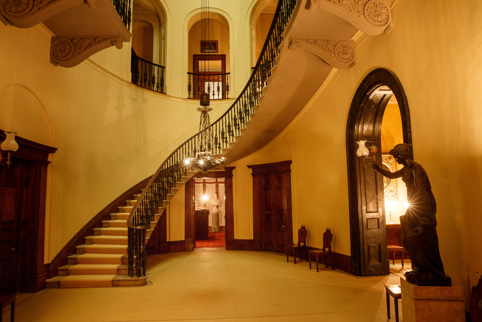 View of the staircase in The Saloon, lit by candle light at Elizabeth Bay House