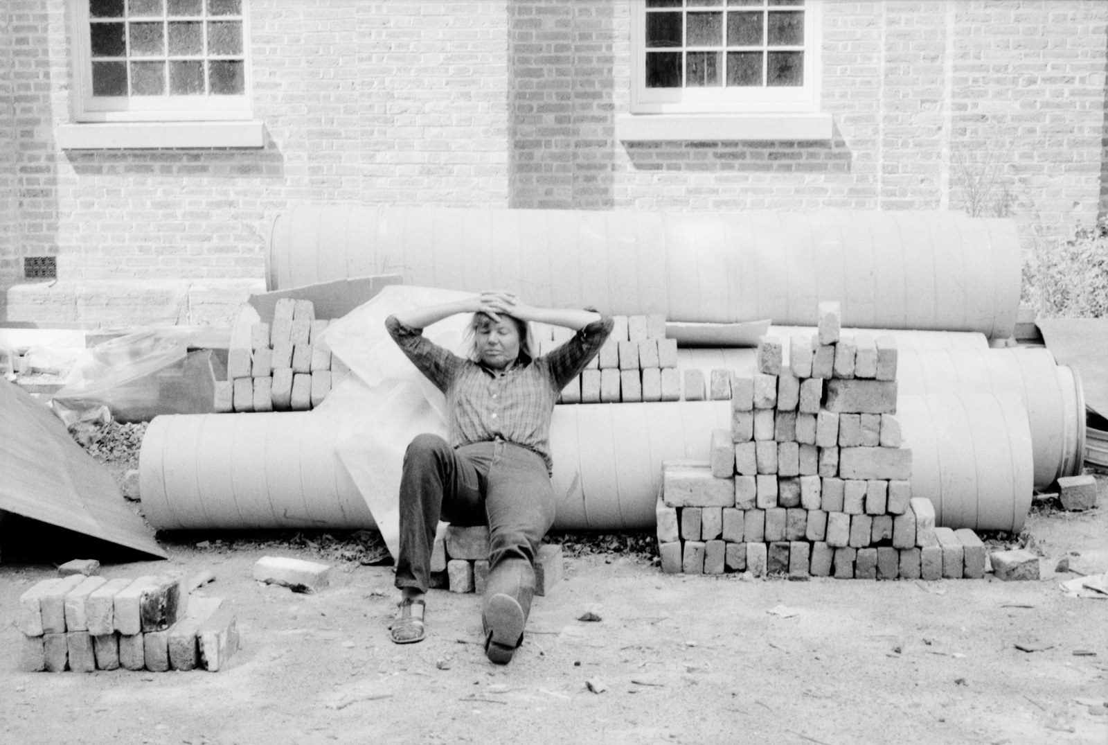 An archaeologist takes a well-earned rest against pipes and convict-made sandstock bricks, Hyde Park Barracks, 1981.