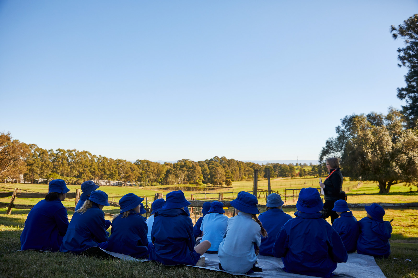 Students sitting on the hillside, creating a watercolour painting of the view towards the Blue Mountains.