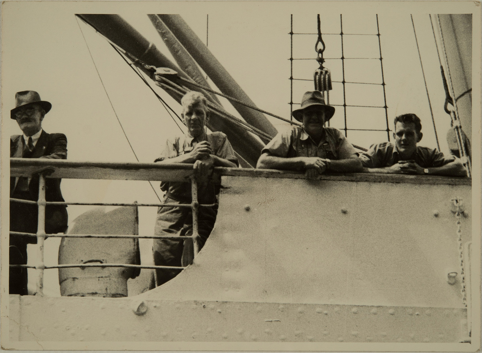 Martin Andersen (second from left) and unknown men standing  on the deck of a boat